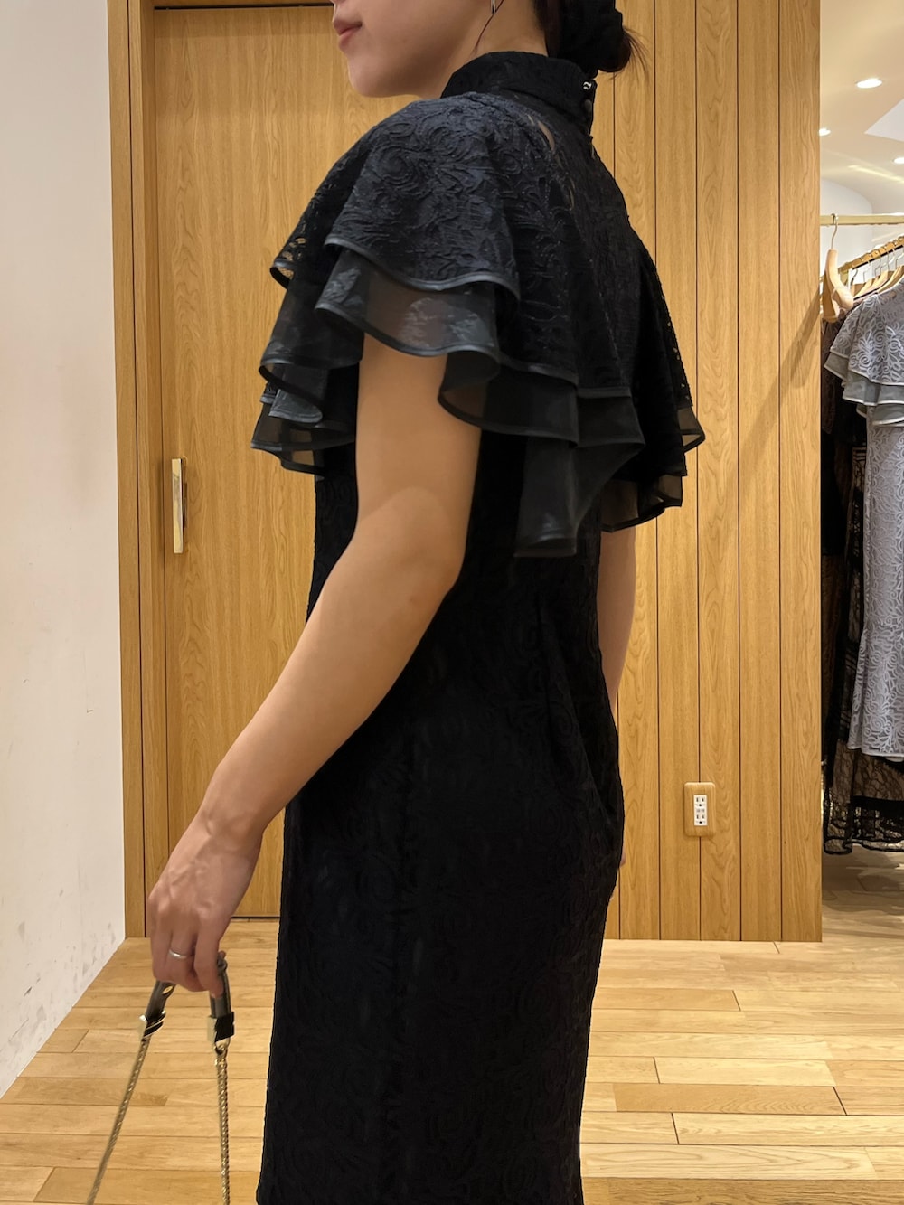 ブラック系のドレス、シルバー系のパンプス、シルバー系のクラッチバッグを着用したレディースの秋コーディネートの5枚目の写真