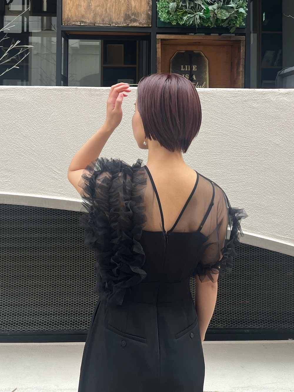 ブラック系のパンツドレス、その他のパンプス、シルバー系のハンドバッグを着用したレディースの冬コーディネートの5枚目の写真