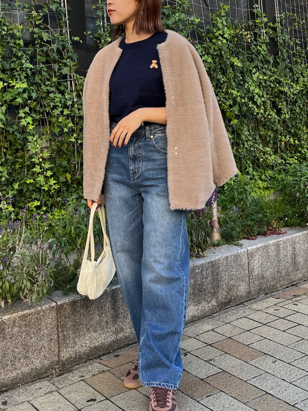 ブルー系のニット/セーター、ブルー系のデニムパンツ、ブラウン系のカーディガン/ボレロを着用したレディースの冬コーディネートの3枚目の写真