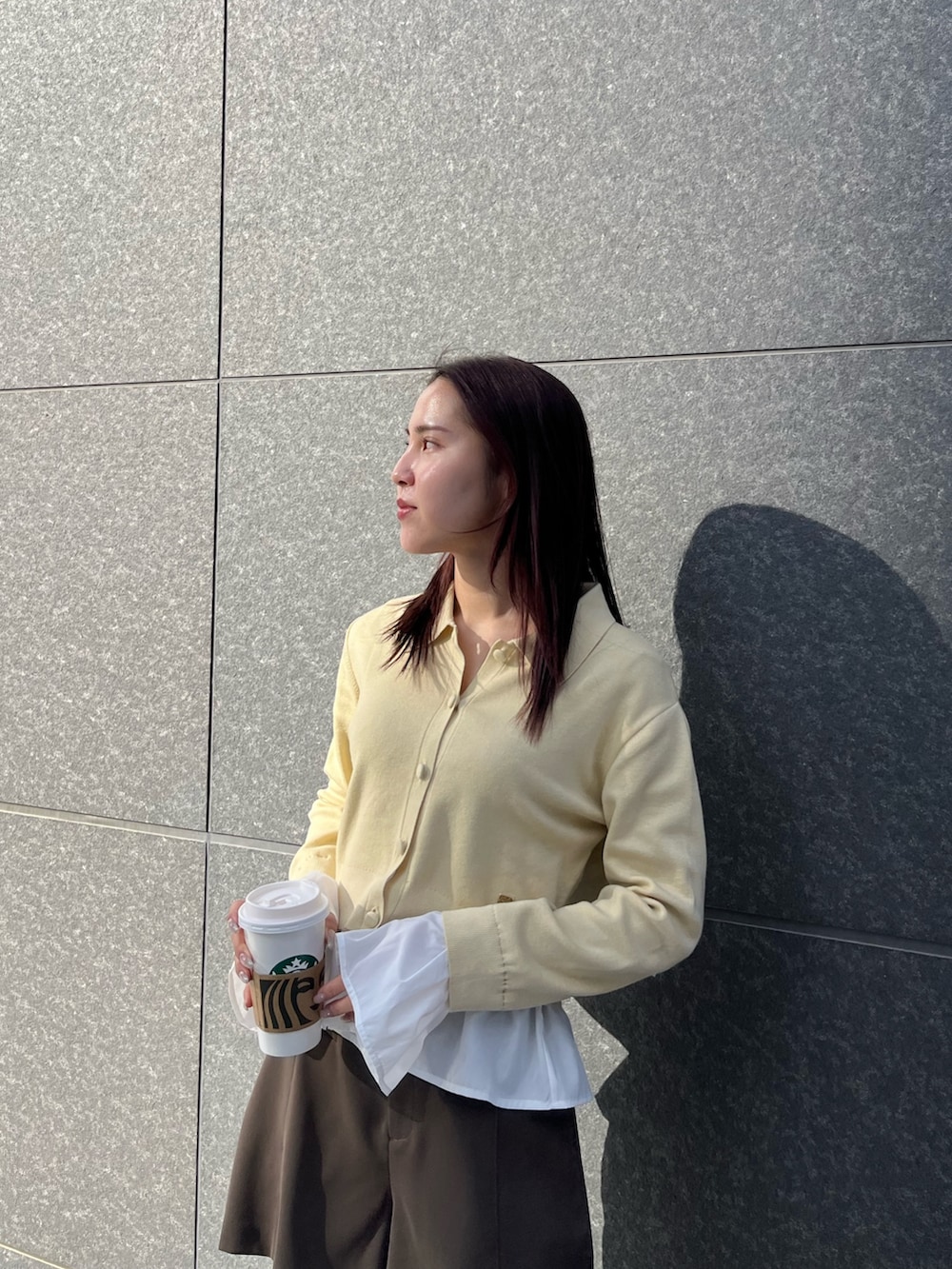 ブラウン系のその他パンツ、ホワイト系のダウンジャケット/コート、イエロー系のカーディガン/ボレロを着用したレディースの冬コーディネートの5枚目の写真