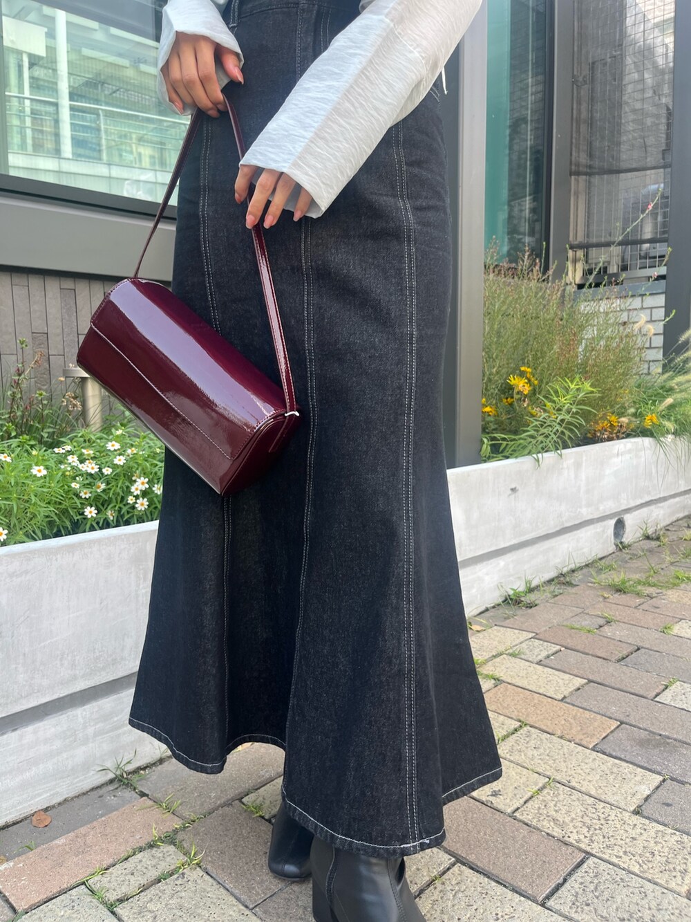 ブラック系のデニムスカート、ブルー系のシャツ/ブラウス、レッド系のショルダーバッグを着用したレディースの秋コーディネートの7枚目の写真