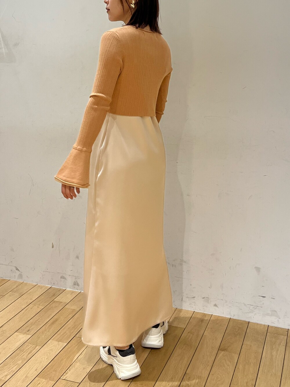 オレンジ系のワンピース、グレー系のスニーカーを着用したレディースの冬コーディネートの3枚目の写真