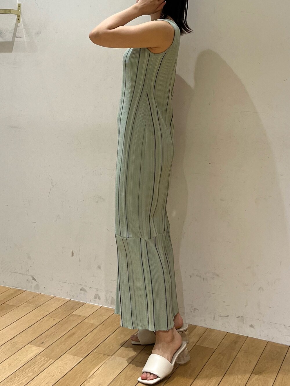 ホワイト系のサンダル、ホワイト系のテーラードジャケット、グリーン系のワンピースを着用したレディースの春コーディネートの2枚目の写真