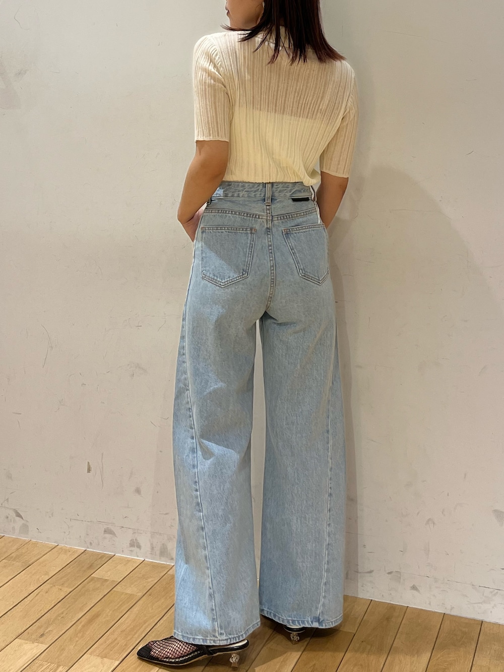 ブルー系のデニムパンツ、ブラック系のサンダル、ホワイト系のTシャツ/カットソーを着用したレディースの春コーディネートの3枚目の写真