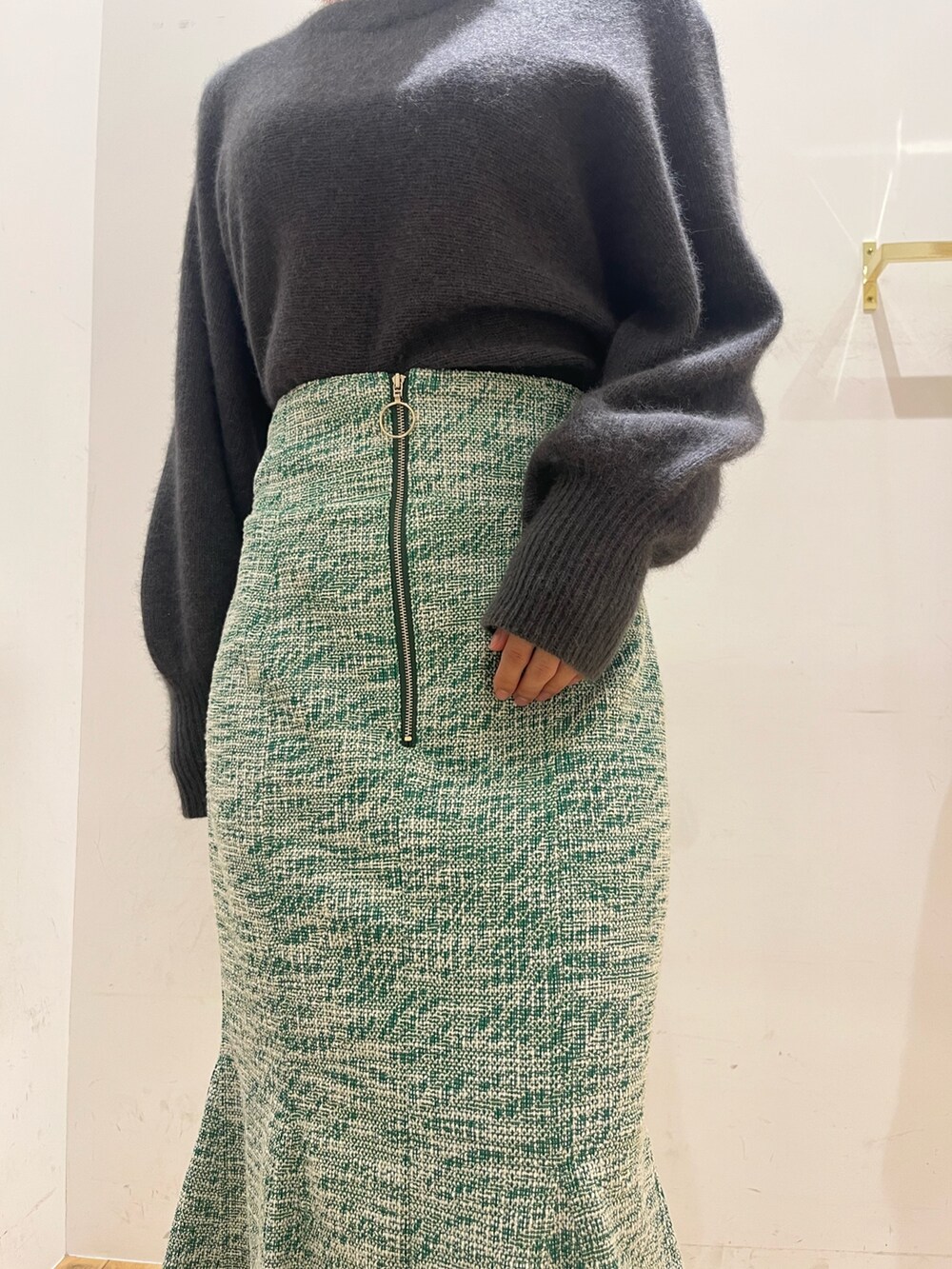 グレー系のニット/セーター、ブラック系のショルダーバッグ、ブラック系のブーツを着用したレディースの秋コーディネートの5枚目の写真