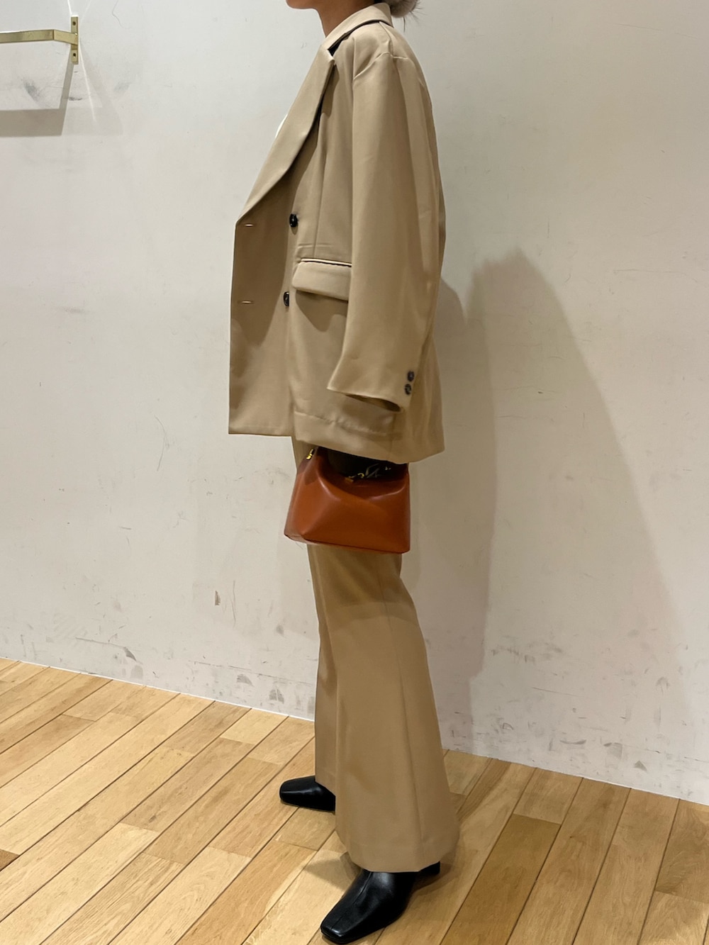 ブラック系のブーツ、ベージュ系のテーラードジャケット、ホワイト系のニット/セーターを着用したレディースの秋コーディネートの2枚目の写真