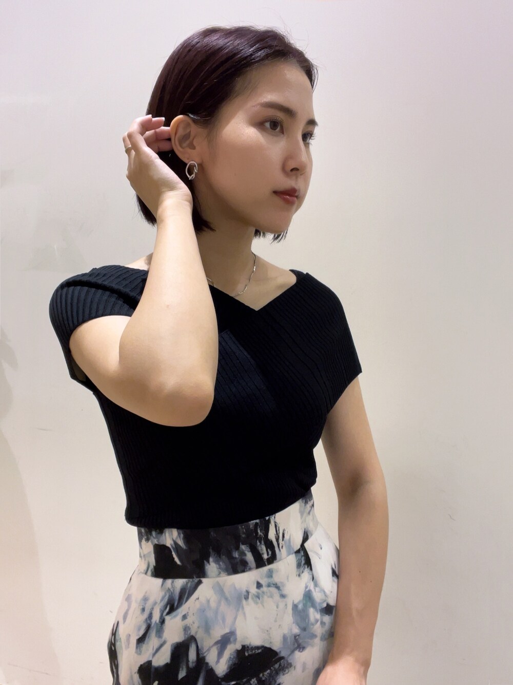 ブラック系のニット/セーター、ブルー系のサンダル、ホワイト系のショルダーバッグを着用したレディースの夏コーディネートの4枚目の写真