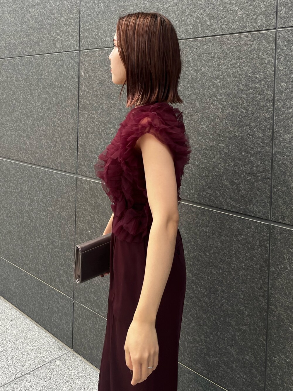 シルバー系のハンドバッグ、レッド系のパンツドレスを着用したレディースの冬コーディネートの5枚目の写真