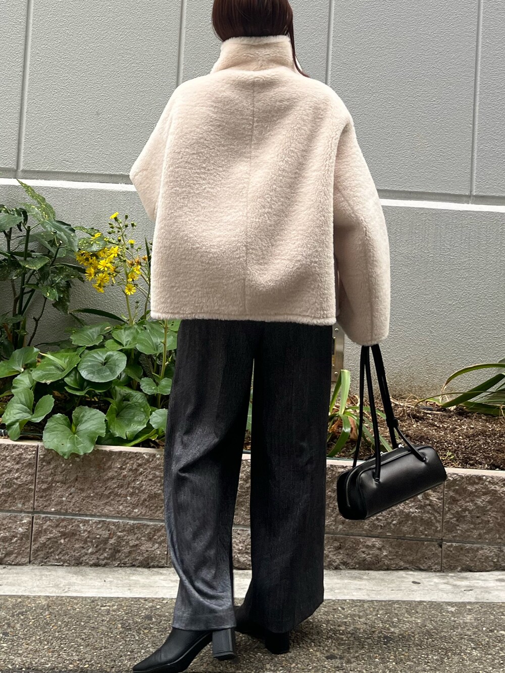 ホワイト系のムートンコート、グレー系のその他パンツ、グリーン系のニット/セーターを着用したレディースの冬コーディネートの6枚目の写真