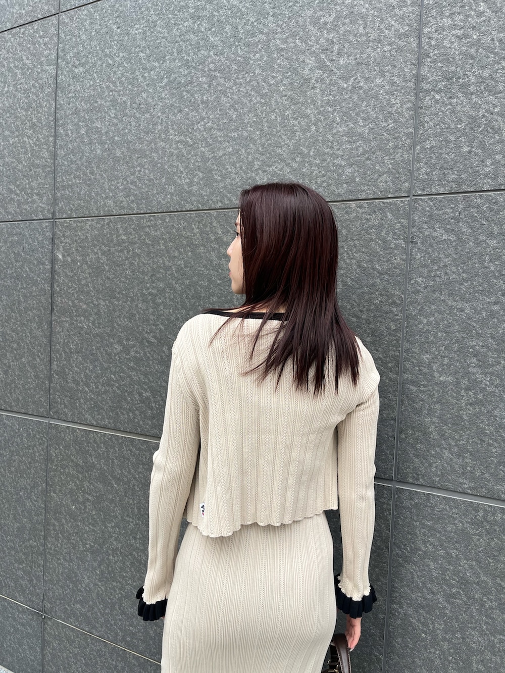 ブラウン系のハンドバッグ、ベージュ系のワンピース、ベージュ系のカーディガン/ボレロを着用したレディースの冬コーディネートの5枚目の写真