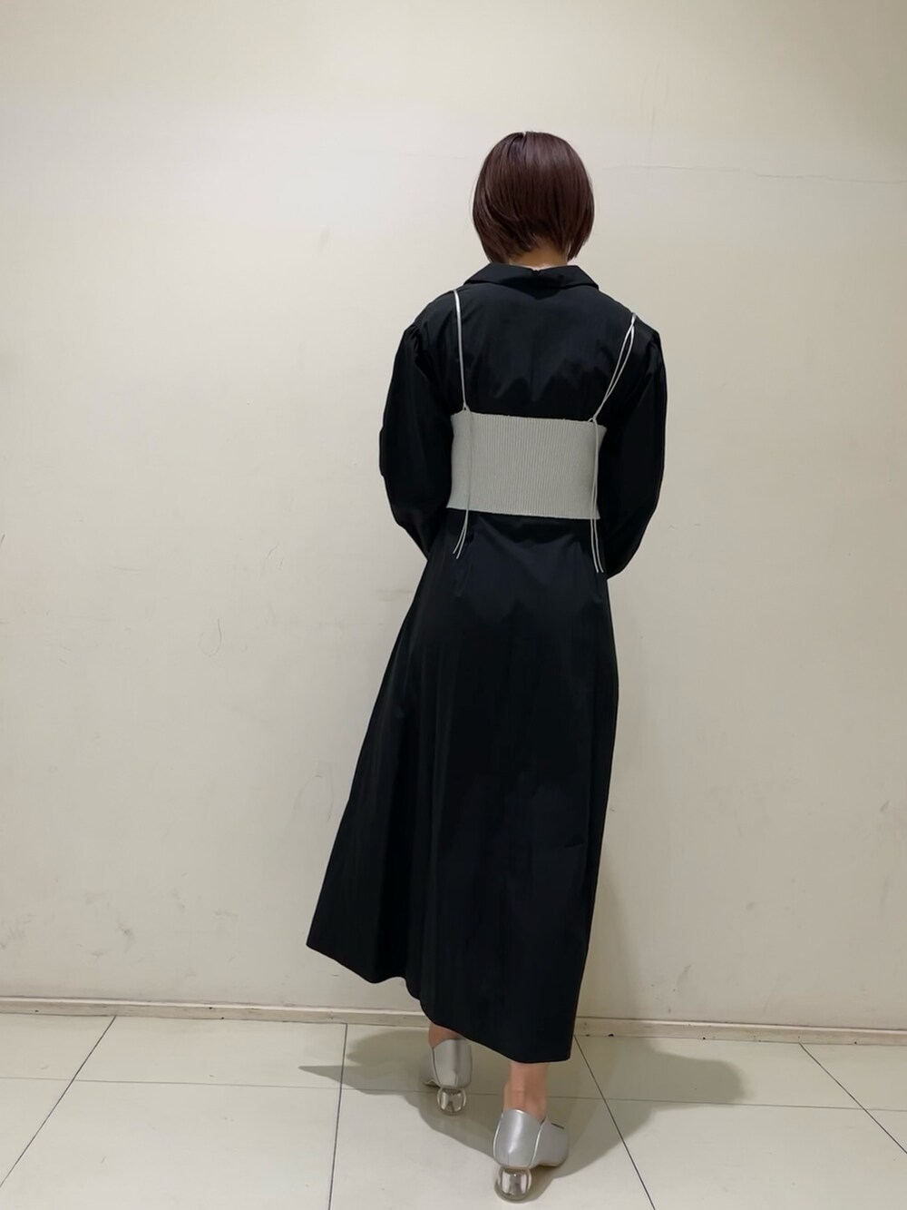 ブラック系のシャツワンピース、ブラック系のハンドバッグ、シルバー系のパンプスを着用したレディースの冬コーディネートの3枚目の写真