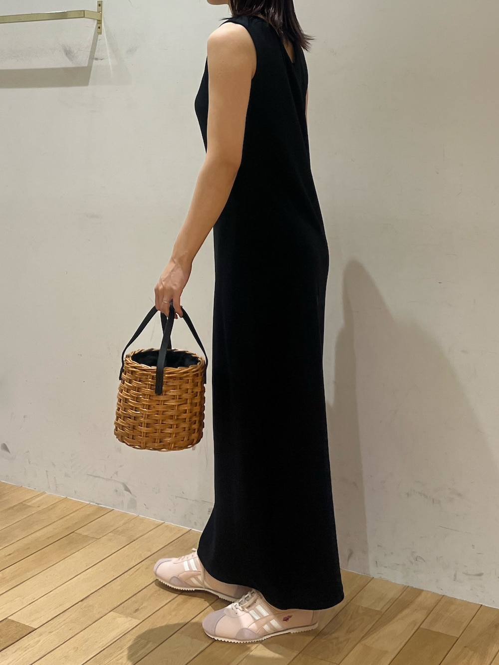 ブラック系のワンピース、ピンク系のスニーカー、ブラウン系のハンドバッグを着用したレディースの夏コーディネートの2枚目の写真