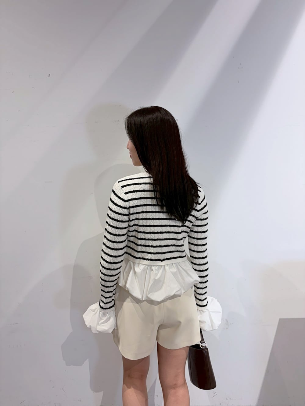 ホワイト系のその他パンツ、ブラック系のブーツ、ブラウン系のハンドバッグを着用したレディースの夏コーディネートの6枚目の写真