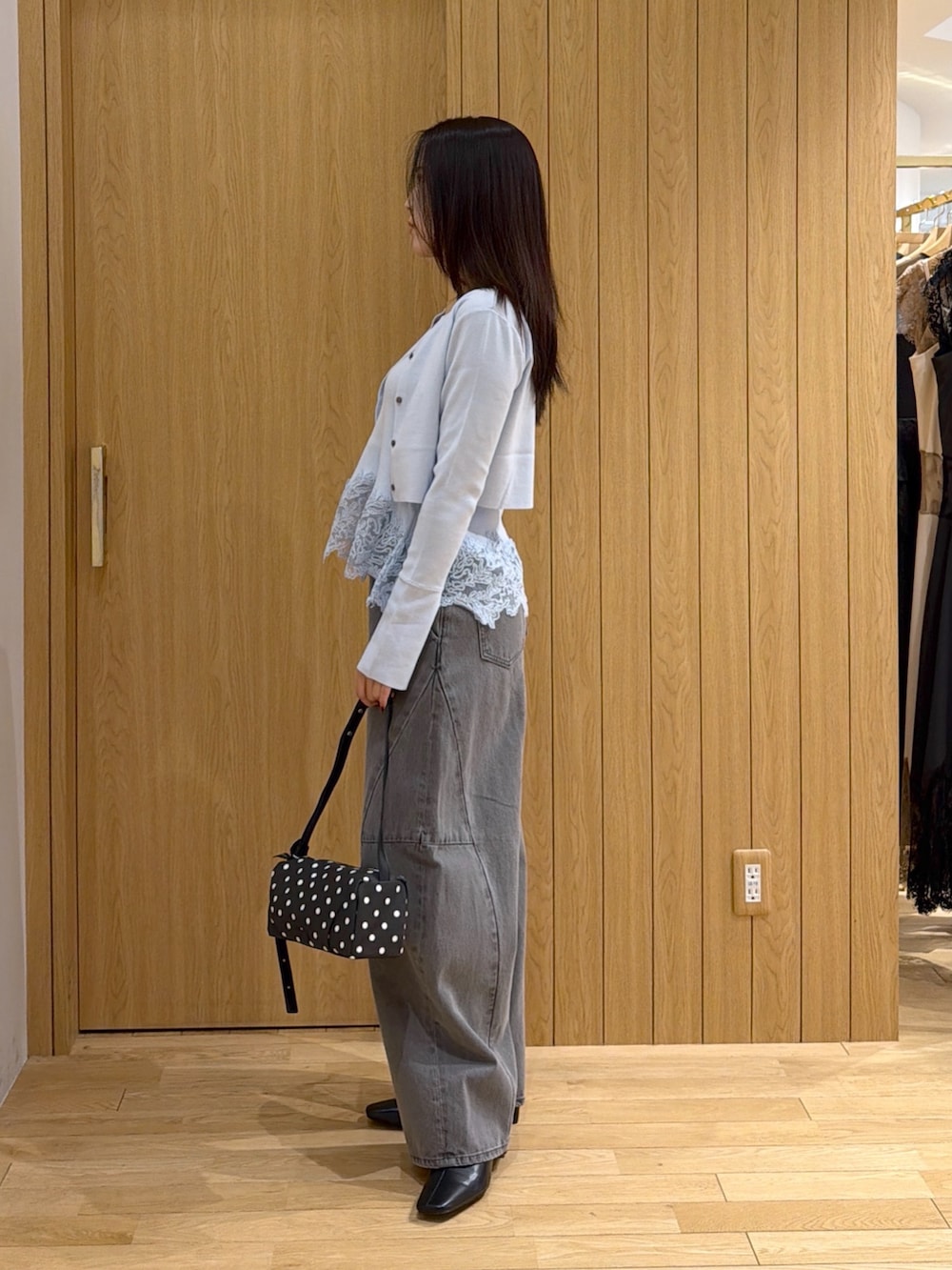 グレー系のデニムパンツ、ブルー系のニット/セーター、ブラック系のブーツを着用したレディースの秋コーディネートの2枚目の写真