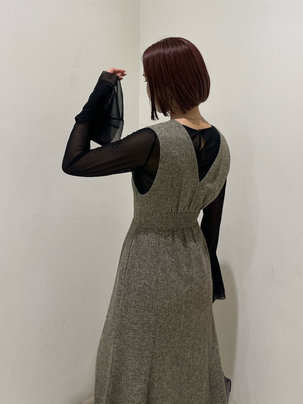 ベージュ系のジャンパースカート、ブラック系のTシャツ/カットソー、ブラック系のブーツを着用したレディースの秋コーディネートの5枚目の写真