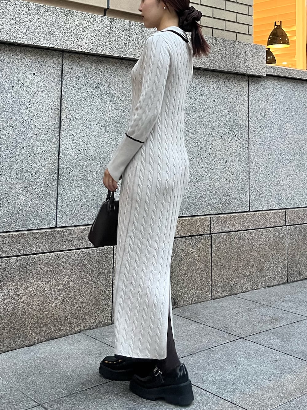 ブラウン系のボストンバッグ、ブラック系のローファー、ベージュ系のワンピースを着用したレディースの秋コーディネートの8枚目の写真