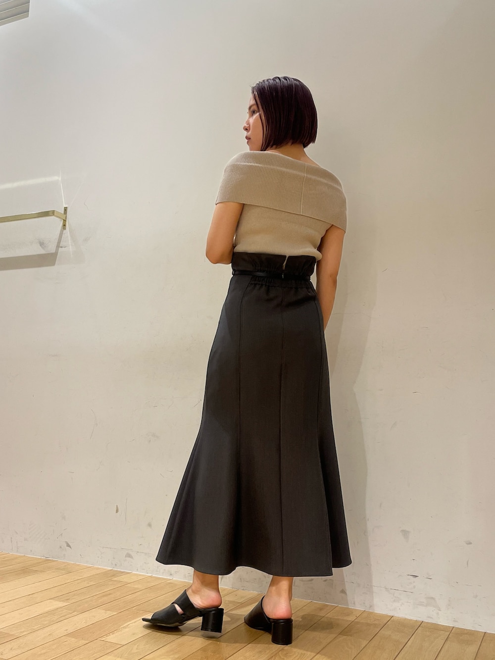 ベージュ系のニット/セーター、ブラック系のサンダル、グレー系のスカートを着用したレディースの夏コーディネートの2枚目の写真