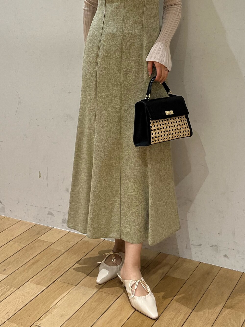 ホワイト系のTシャツ/カットソー、グリーン系のジャンパースカート、ホワイト系のサンダルを着用したレディースの春コーディネートの6枚目の写真