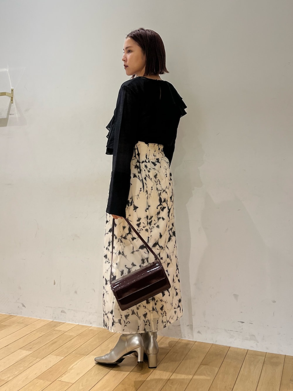 ホワイト系のスカート、レッド系のショルダーバッグ、ブラック系のシャツ/ブラウスを着用したレディースの秋コーディネートの3枚目の写真