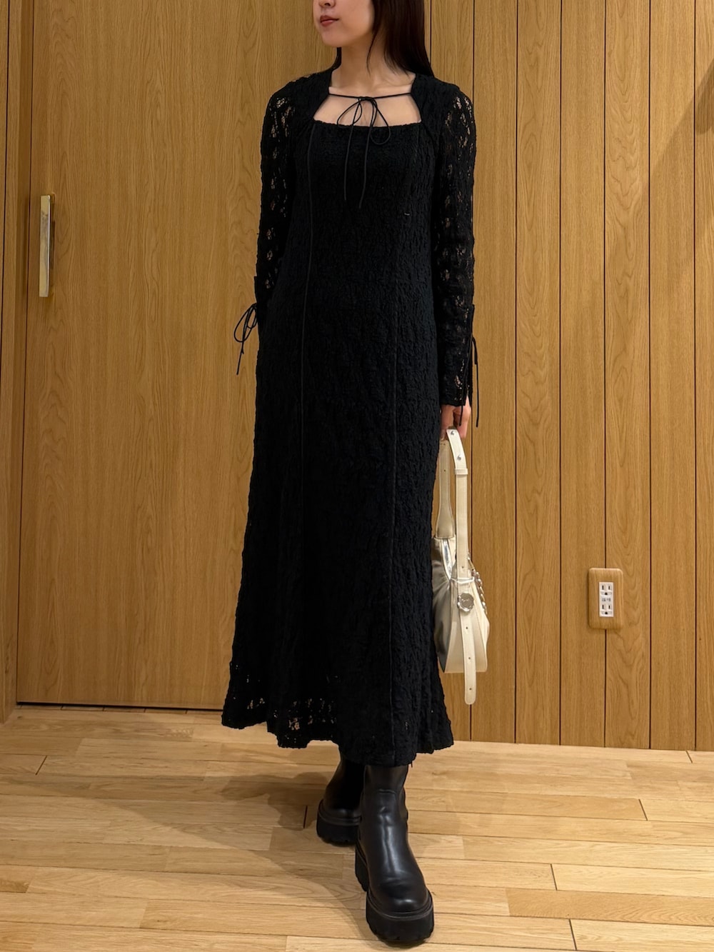 ブラック系のワンピース、ベージュ系のトレンチコートを着用したレディースの春コーディネートの4枚目の写真