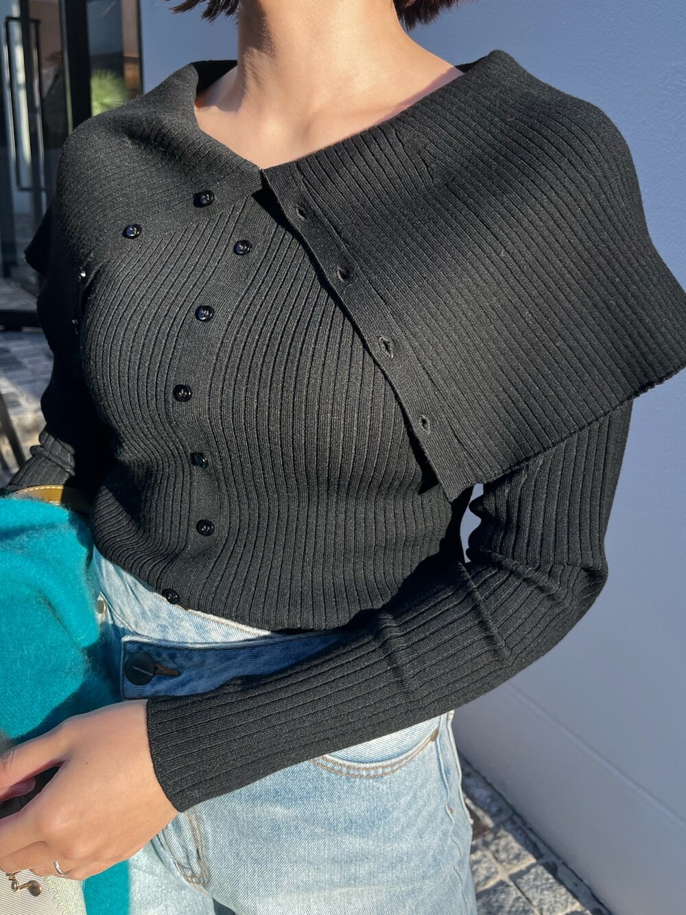 ブルー系のデニムパンツ、ブルー系のカーディガン/ボレロ、ブラック系のニット/セーターを着用したレディースの冬コーディネートの7枚目の写真