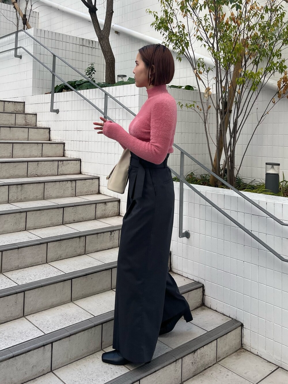 グレー系のその他パンツ、ホワイト系のハンドバッグ、ホワイト系のダウンジャケット/コートを着用したレディースの冬コーディネートの6枚目の写真