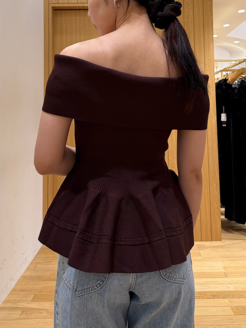 ブラウン系のニット/セーター、ブルー系のデニムパンツ、ホワイト系のハンドバッグを着用したレディースの夏コーディネートの7枚目の写真