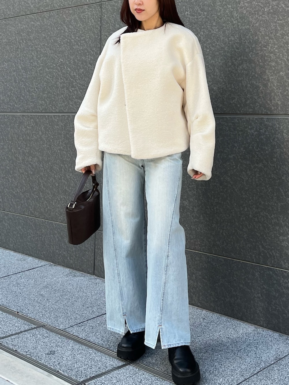 ブルー系のアンサンブル、ブルー系のデニムパンツ、ホワイト系のブルゾンを着用したレディースの冬コーディネートの2枚目の写真