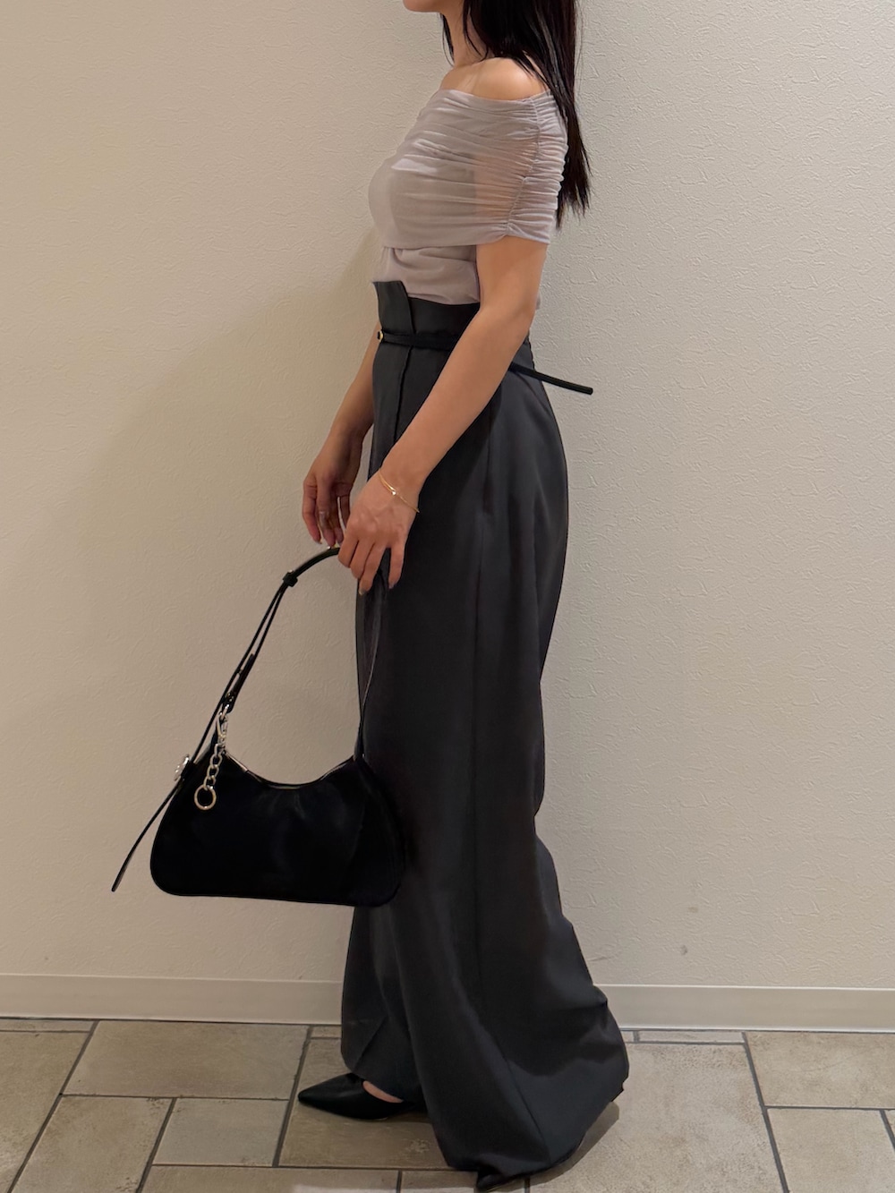 ブラック系のハンドバッグ、ブラック系のパンプス、グレー系のその他パンツを着用したレディースの夏コーディネートの2枚目の写真