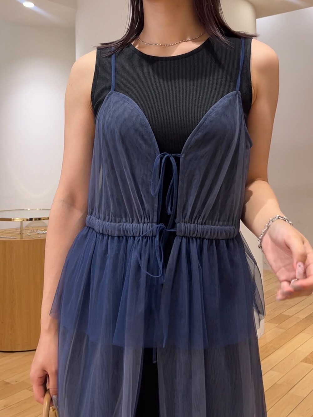 ブラウン系のハンドバッグ、ブラック系のスニーカー、ブルー系のワンピースを着用したレディースの夏コーディネートの5枚目の写真