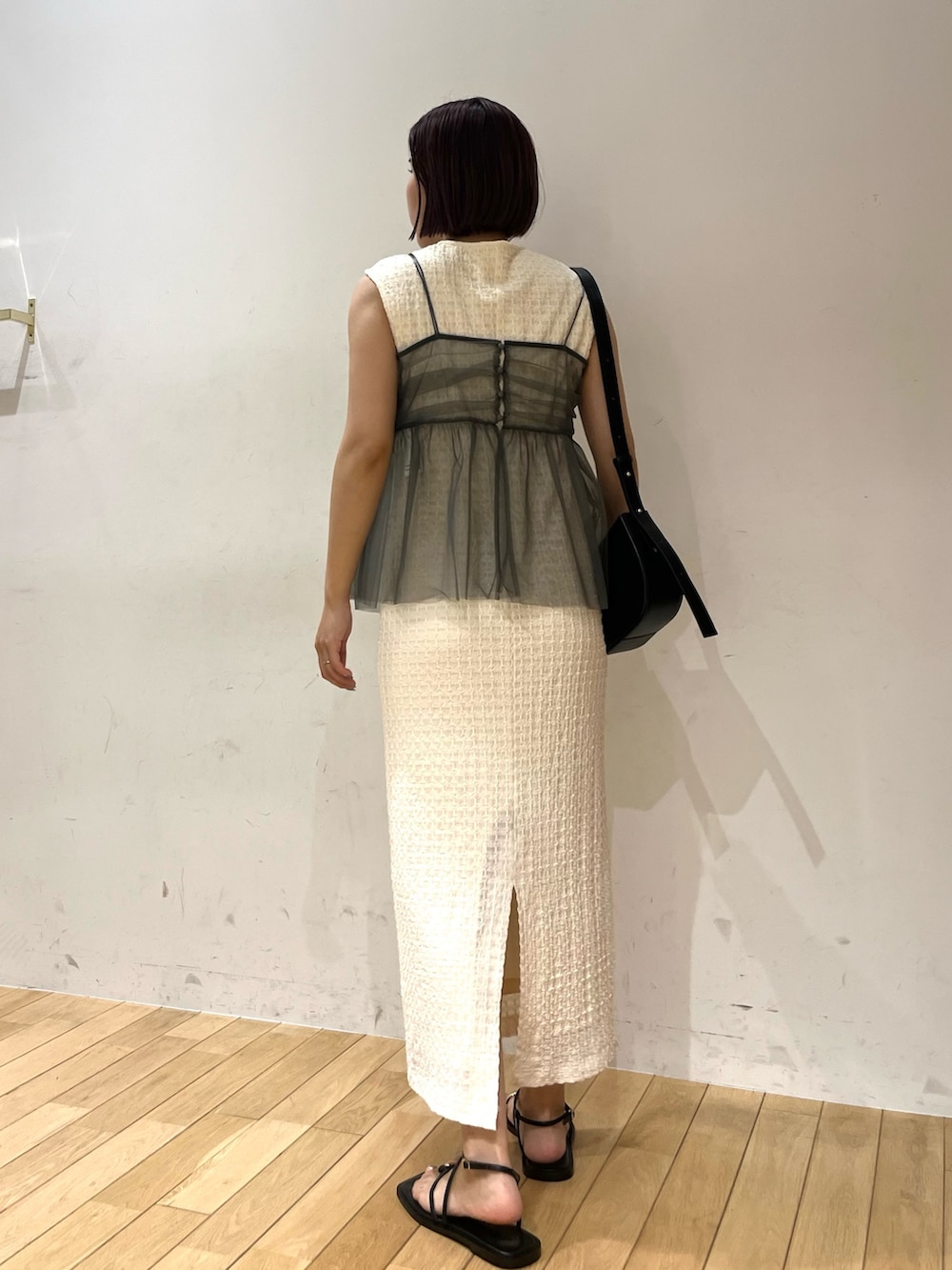 ホワイト系のワンピース、ブラック系のショルダーバッグ、ブラック系のサンダルを着用したレディースの夏コーディネートの3枚目の写真