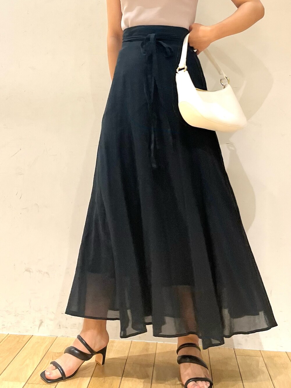 パープル系のニット/セーター、ブラック系のサンダル、ブラック系のスカートを着用したレディースの夏コーディネートの4枚目の写真