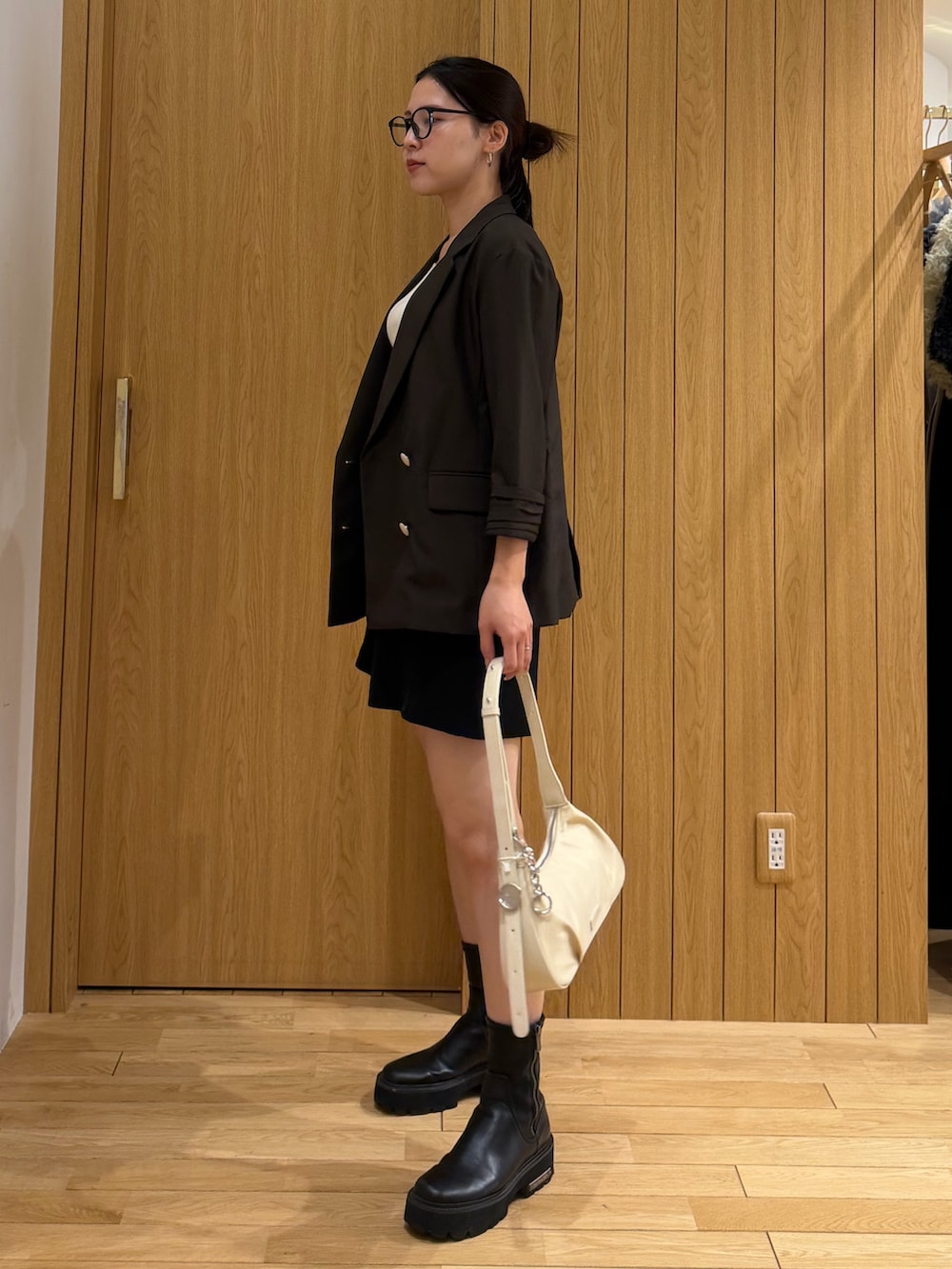 ブラック系のその他パンツ、ブラウン系のテーラードジャケット、ホワイト系のハンドバッグを着用したレディースの春コーディネートの2枚目の写真