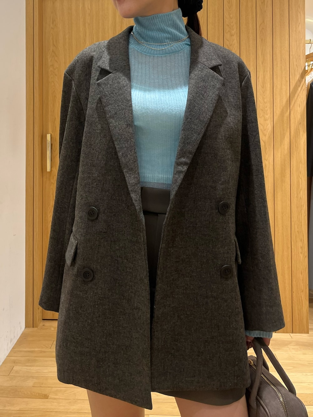 ブルー系のニット/セーター、ブラウン系のテーラードジャケット、ブラウン系のその他パンツを着用したレディースの秋コーディネートの5枚目の写真