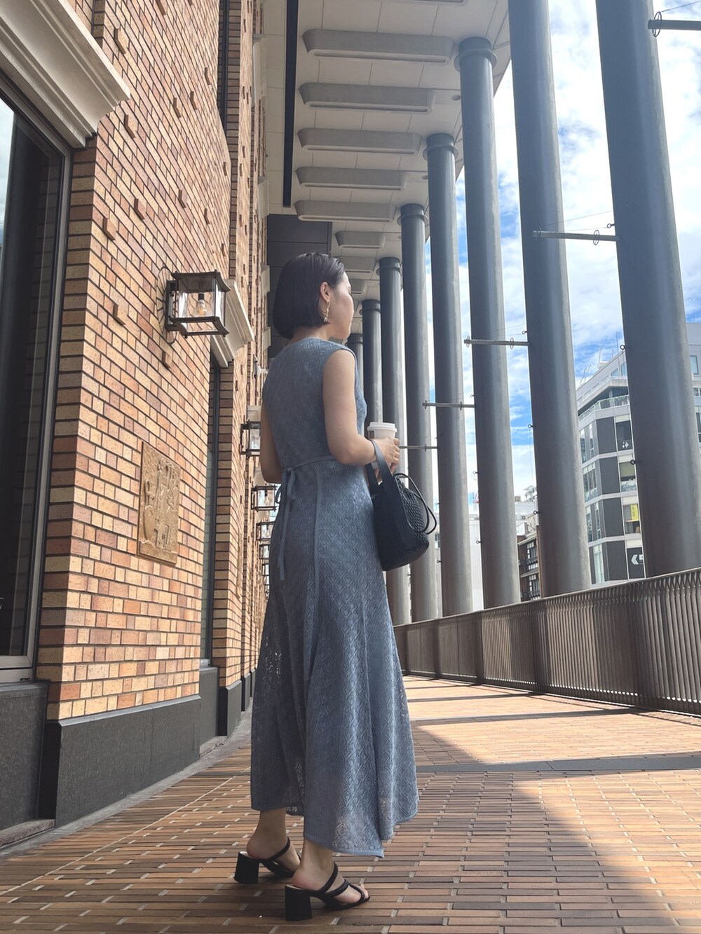 ホワイト系のハンドバッグ、ブルー系のワンピースを着用したレディースの夏コーディネートの3枚目の写真