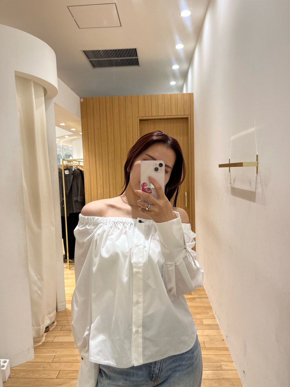 ブルー系のデニムパンツ、シルバー系のサンダル、ブラウン系のハンドバッグを着用したレディースの春コーディネートの6枚目の写真