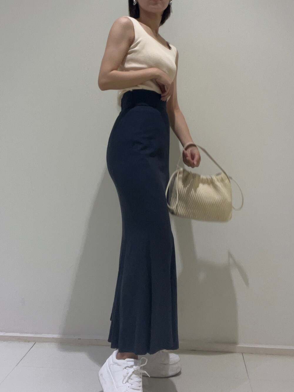 ホワイト系のニット/セーター、ブルー系のスカート、ブルー系のシャツ/ブラウスを着用したレディースの春コーディネートの2枚目の写真