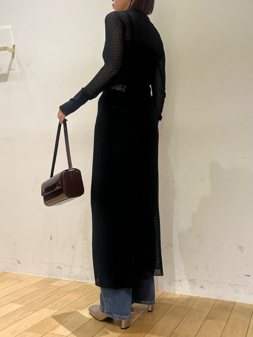 ブラック系のワンピース、レッド系のショルダーバッグ、シルバー系のブーツを着用したレディースの秋コーディネートの2枚目の写真