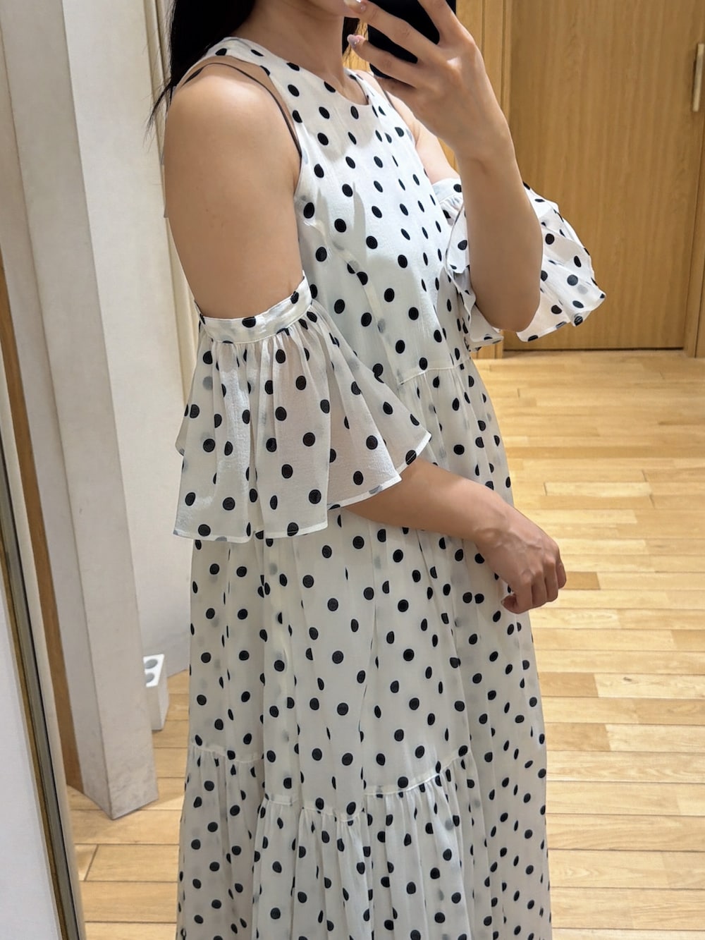 ブラック系のハンドバッグ、ブラック系のパンプス、ホワイト系のワンピースを着用したレディースの春コーディネートの6枚目の写真