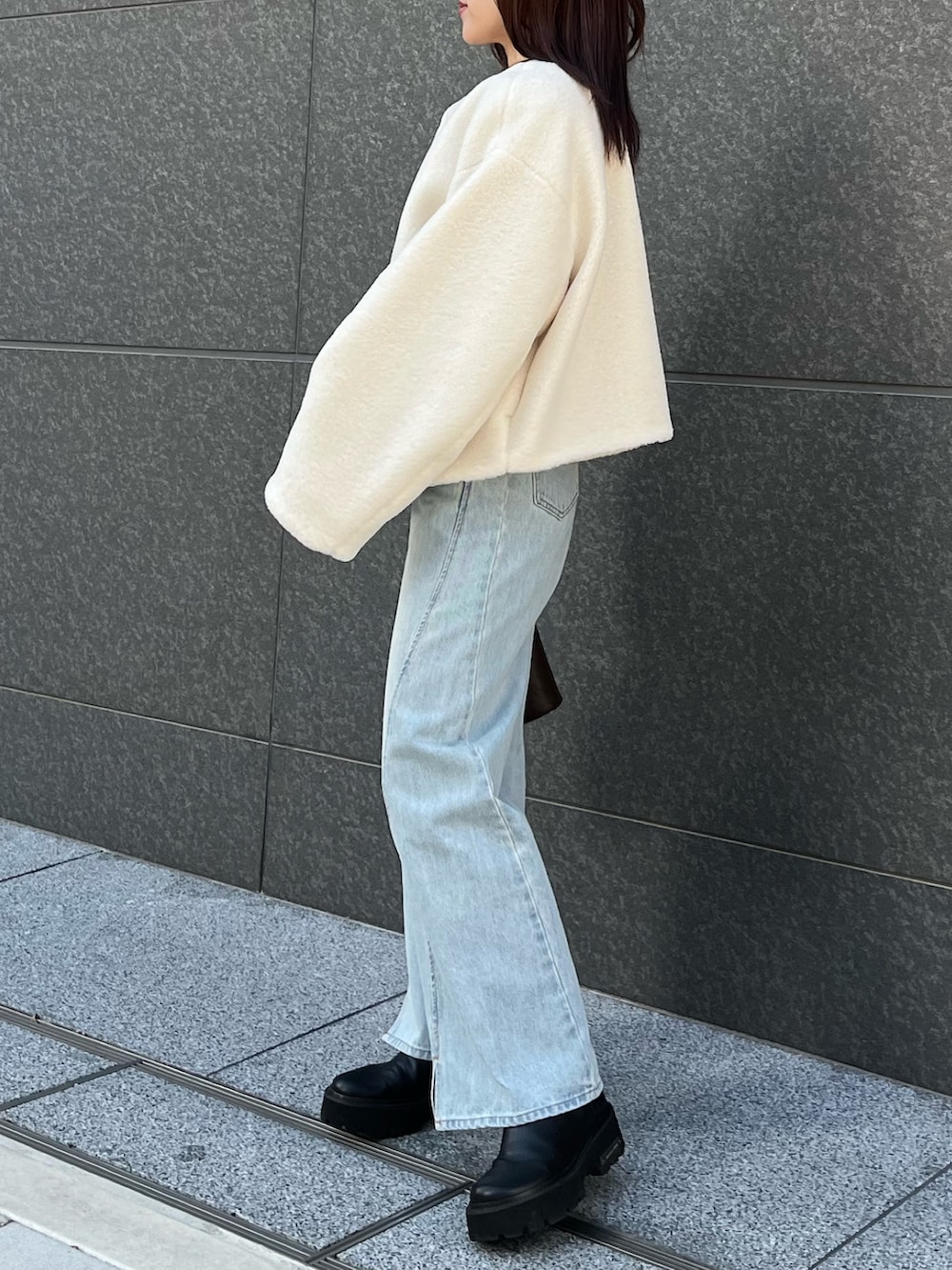 ブルー系のアンサンブル、ブルー系のデニムパンツ、ホワイト系のブルゾンを着用したレディースの冬コーディネートの3枚目の写真