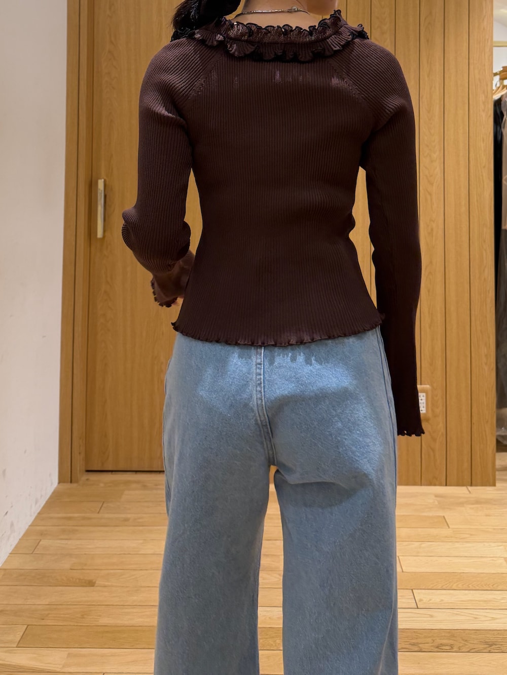 ブラウン系のニット/セーター、ブルー系のデニムパンツ、ブラック系のサンダルを着用したレディースの春コーディネートの5枚目の写真