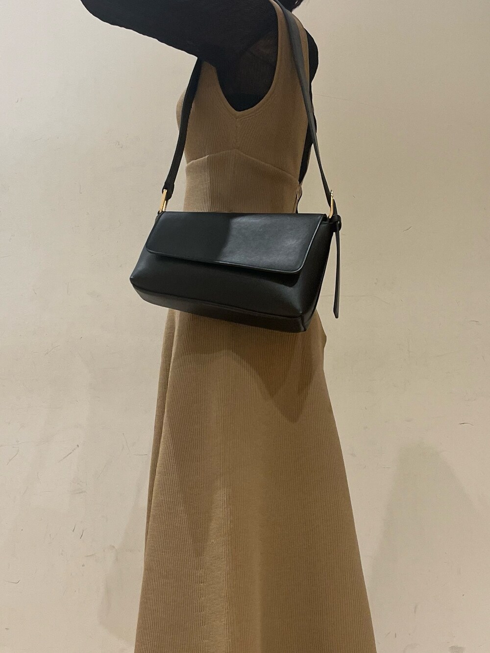 ブラック系のブーツ、ブラウン系のジャンパースカート、ブラック系のショルダーバッグを着用したレディースの秋コーディネートの5枚目の写真