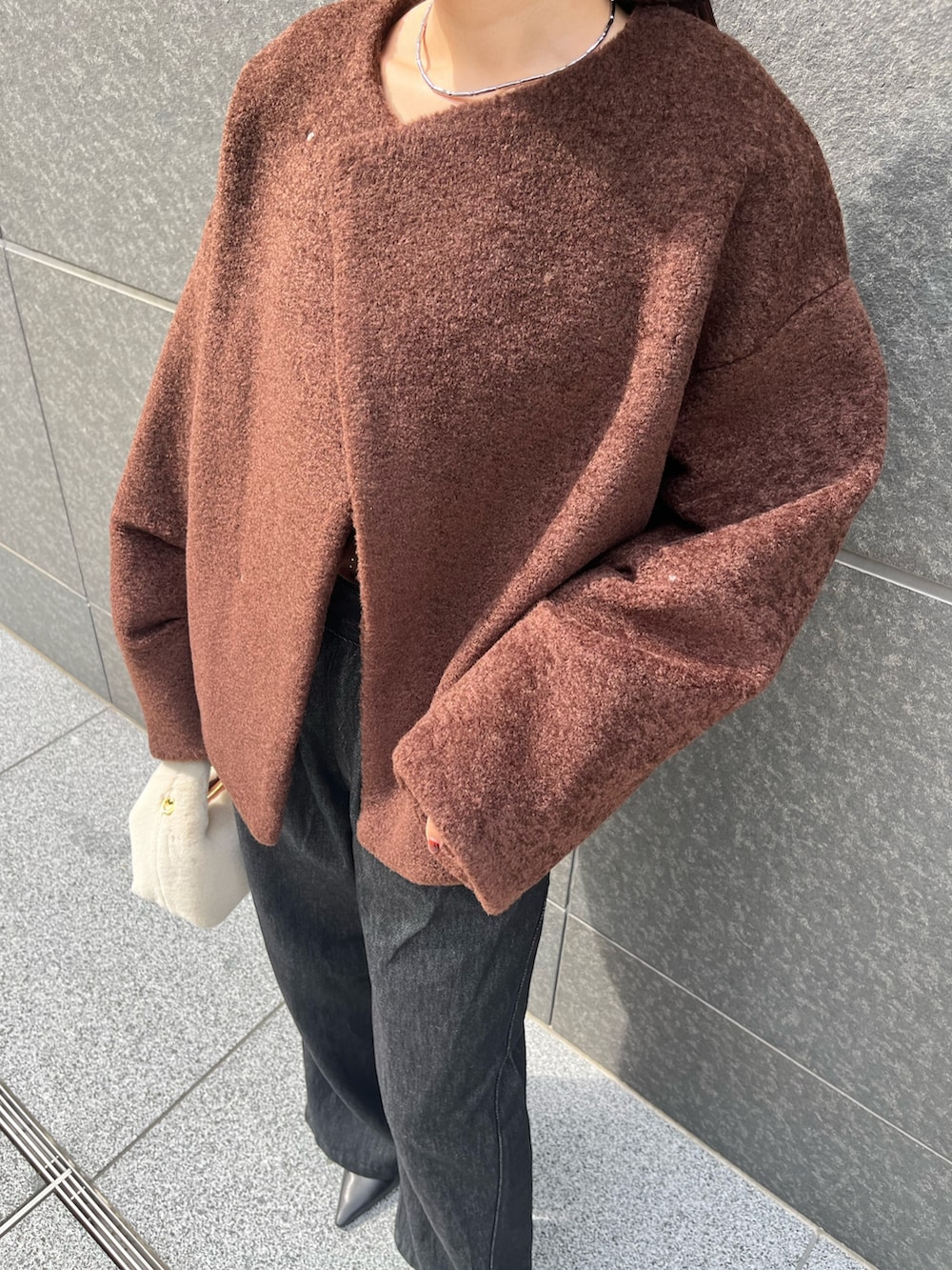 ブラック系のデニムパンツ、ホワイト系のハンドバッグ、ブラウン系のTシャツ/カットソーを着用したレディースの秋コーディネートの7枚目の写真