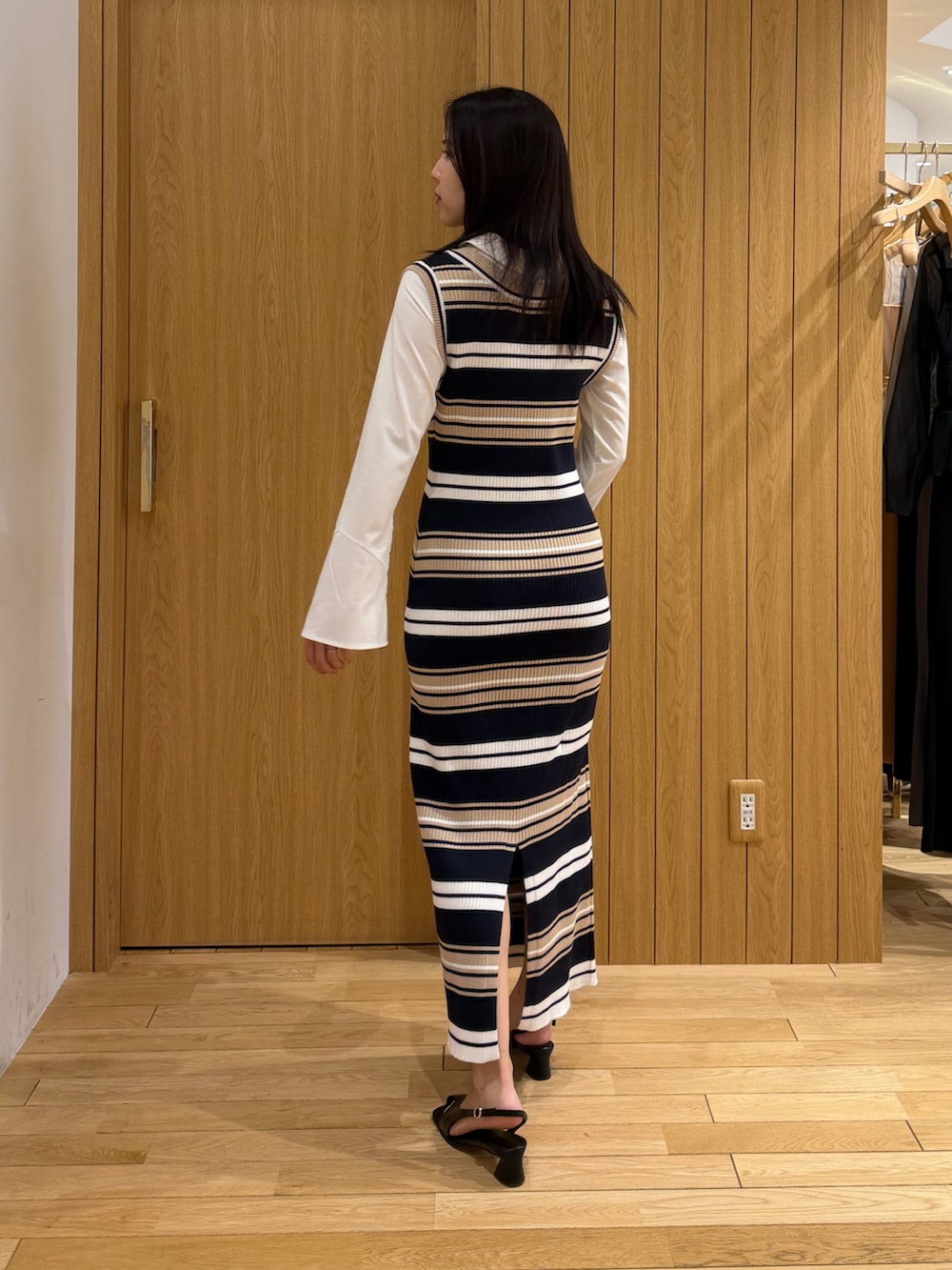 ベージュ系のワンピース、ブラック系のサンダルを着用したレディースの冬コーディネートの3枚目の写真