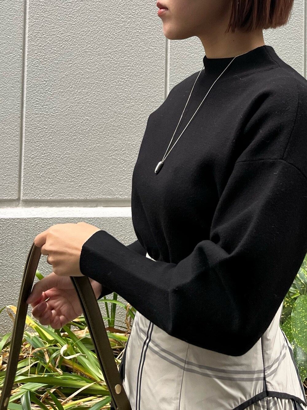 ホワイト系のワンピース、ブラック系のブーツ、ブラウン系のショルダーバッグを着用したレディースの冬コーディネートの7枚目の写真