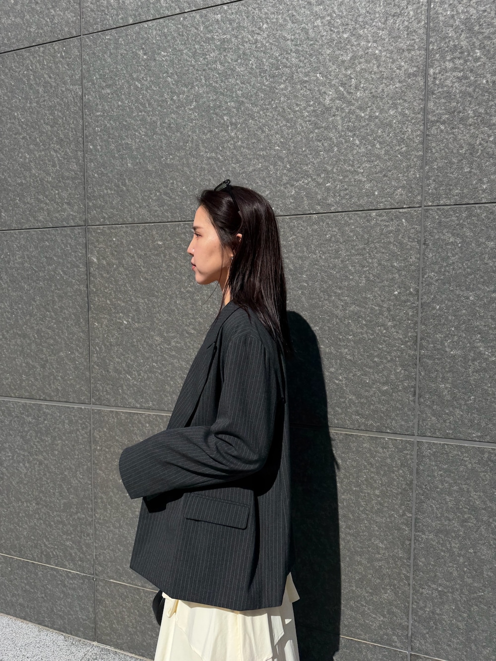 ホワイト系のスカート、ブラック系のニット/セーター、ブラック系のハンドバッグを着用したレディースの冬コーディネートの4枚目の写真