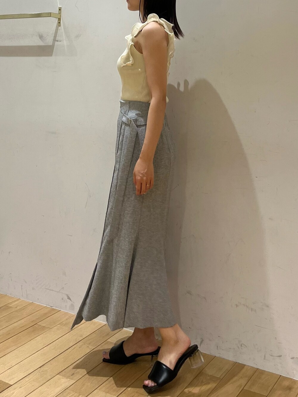 ホワイト系のニット/セーター、グレー系のスカート、ブラック系のサンダルを着用したレディースの夏コーディネートの2枚目の写真