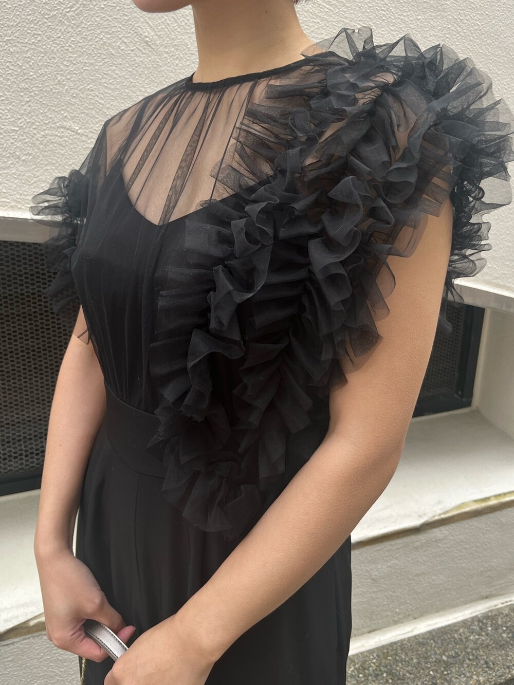 ブラック系のパンツドレス、その他のパンプス、シルバー系のハンドバッグを着用したレディースの冬コーディネートの7枚目の写真