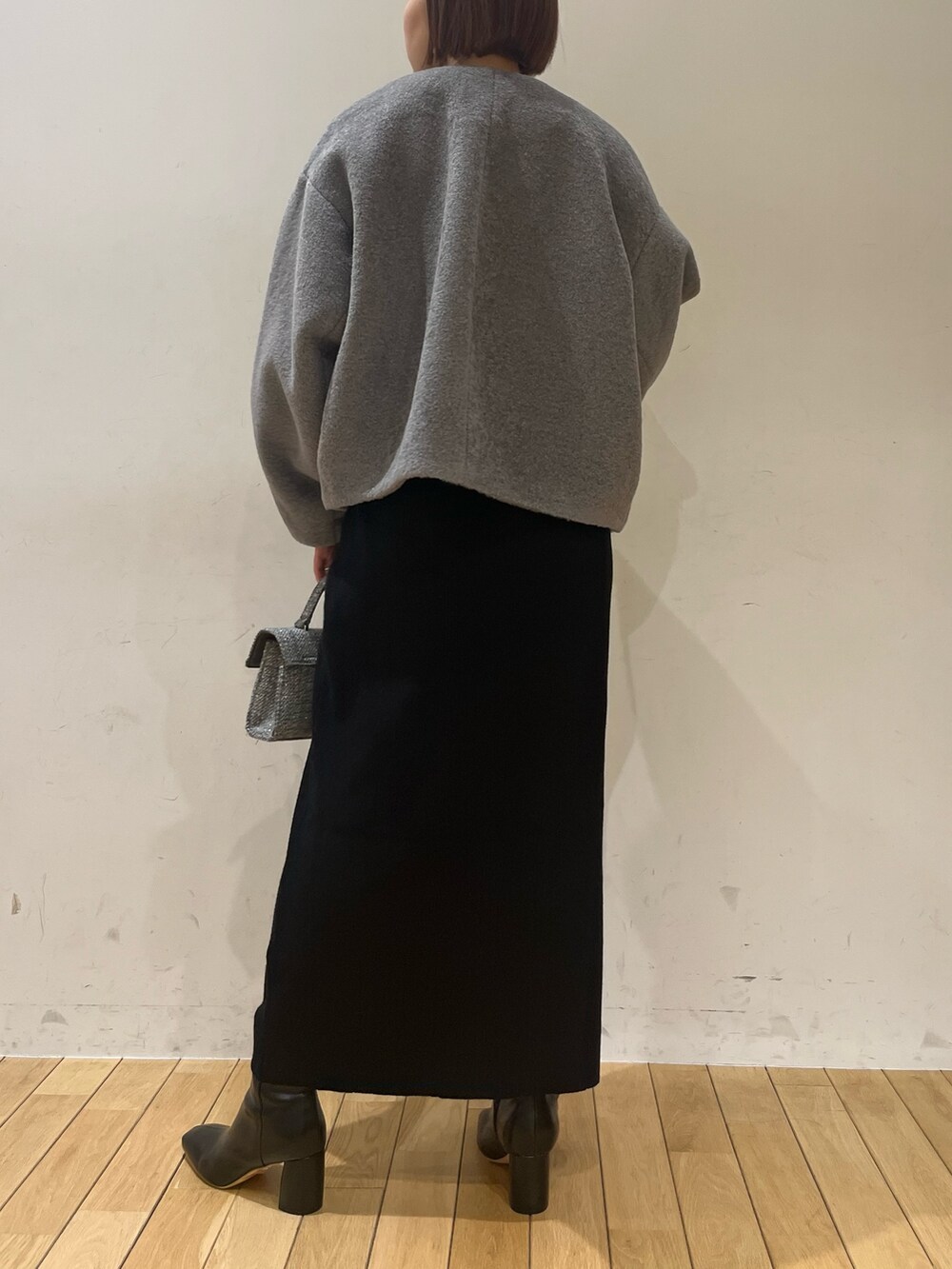 ブラック系のブーツ、グレー系のブルゾン、ブラック系のワンピースを着用したレディースの冬コーディネートの3枚目の写真