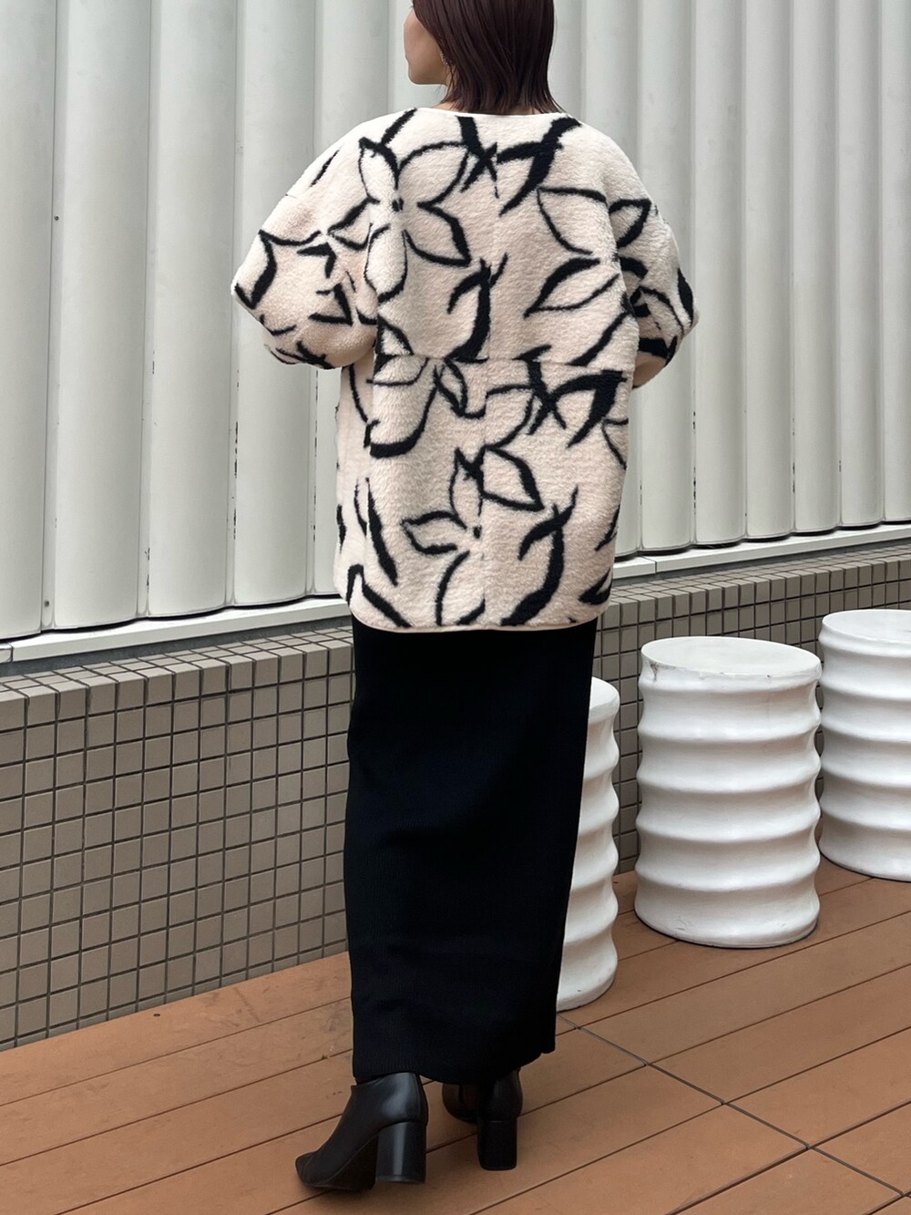 ブラック系のワンピース、ホワイト系のブルゾン、ホワイト系のTシャツ/カットソーを着用したレディースの秋コーディネートの3枚目の写真